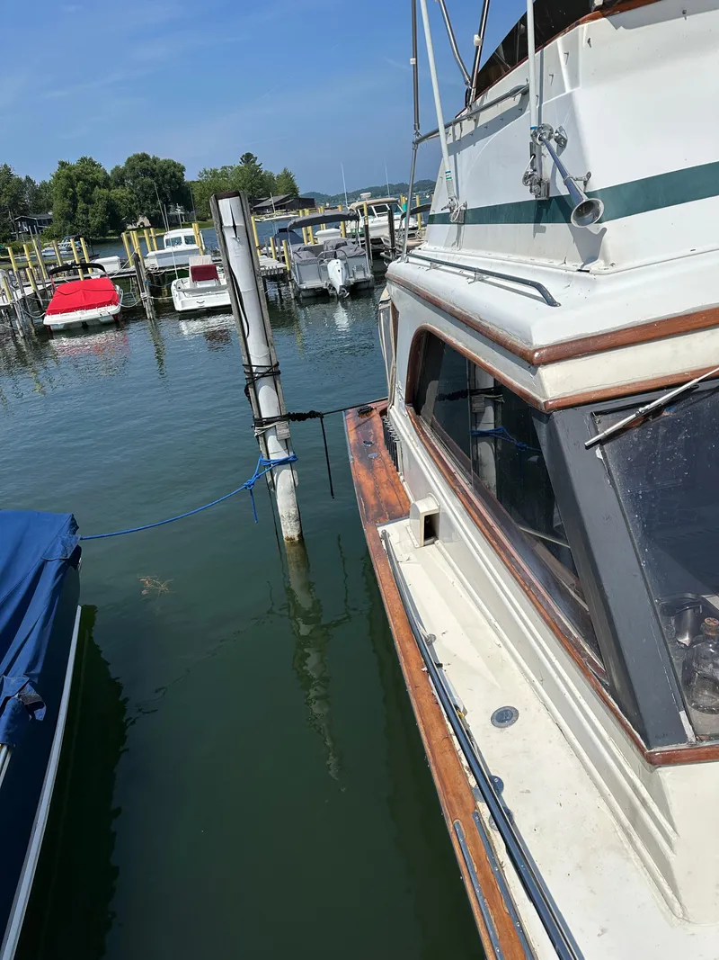 Slide: The Image of 1977 Egg Harbor 33 Sedan docked at a marina on a sunny day. - 6