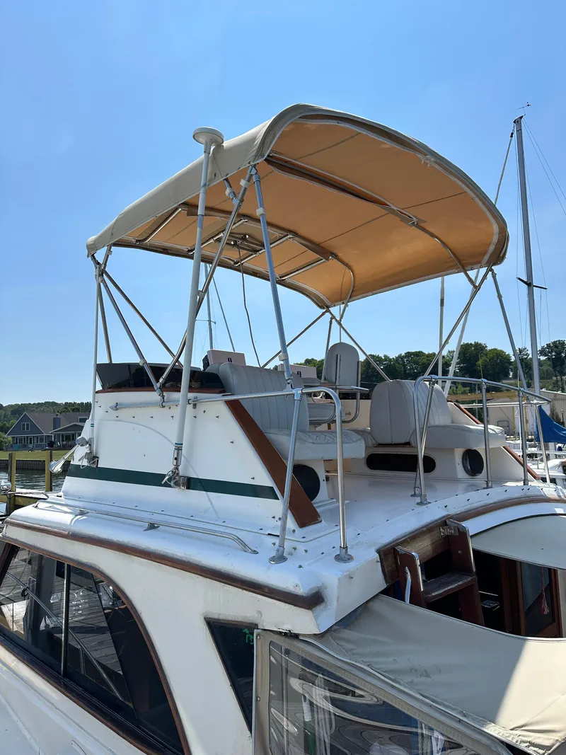 Slide: The Image of 1977 Egg Harbor 33 Sedan boat with canopy, docked under clear blue sky. - 7