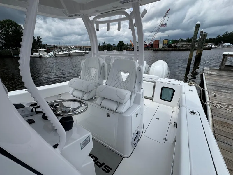 Slide: The Image of 2024 Sportsman Open 302 Center Console boat docked, featuring luxurious seating and modern design. - 11