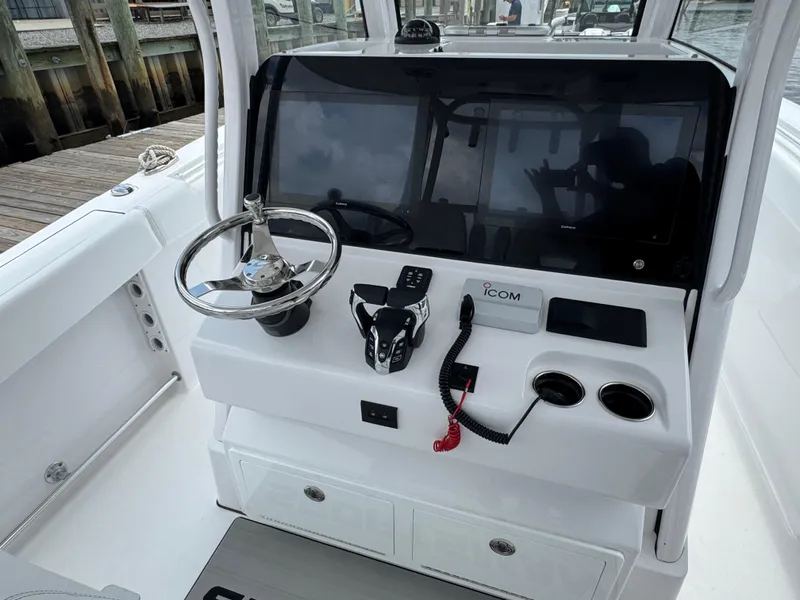 Slide: The Image of 2024 Sportsman Open 302 Center Console helm with steering wheel and electronic controls. - 5