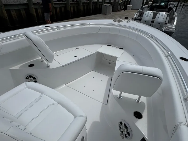 Slide: The Image of 2024 Sportsman Open 302 Center Console boat interior with white seating and storage compartments. - 8