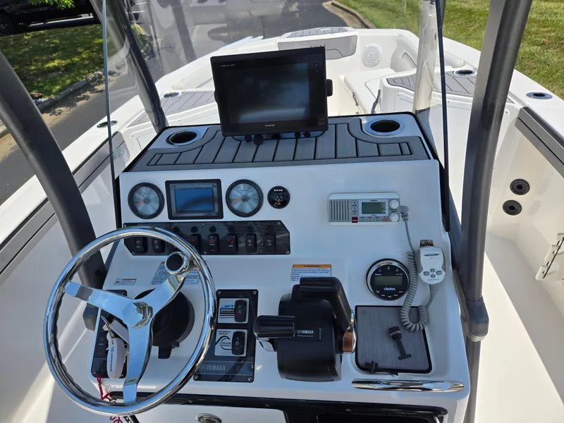 Slide: The Image of 2018 Yamaha Boats 210 FSH Sport dashboard with steering wheel and navigation controls. - 11