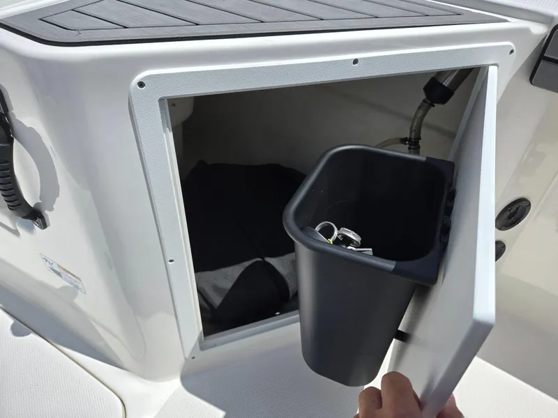 Slide: The Image of 2018 Yamaha Boats 210 FSH Sport storage compartment with trash bin. - 13