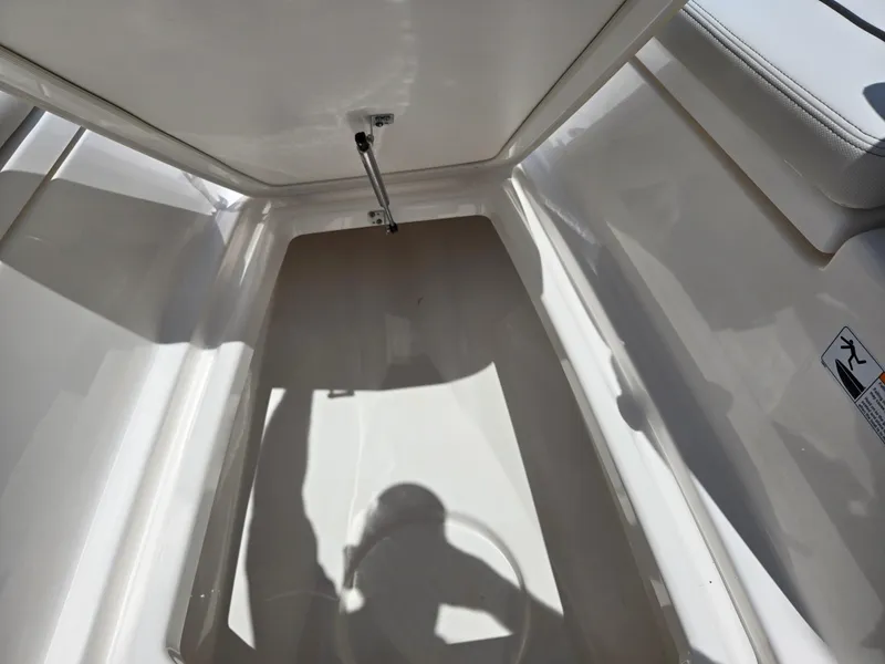 Slide: The Image of 2018 Yamaha Boats 210 FSH Sport storage compartment with open hatch. - 14