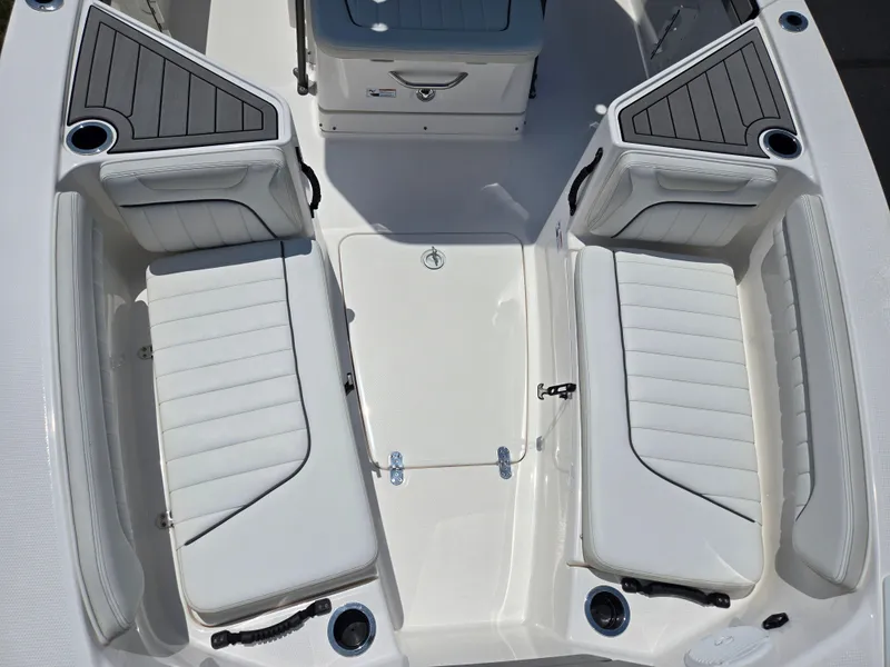 Slide: The Image of 2018 Yamaha Boats 210 FSH Sport interior with white seating and storage compartments. - 16