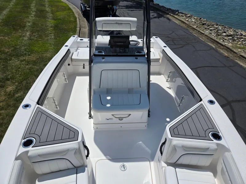 Slide: The Image of 2018 Yamaha Boats 210 FSH Sport interior with seating and storage, docked by a lake. - 17