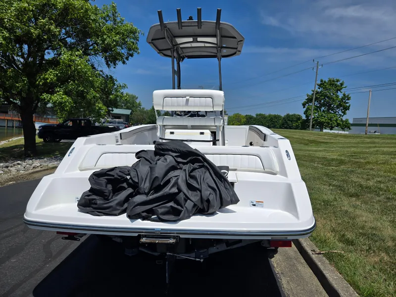 Slide: The Image of 2018 Yamaha Boats 210 FSH Sport on trailer, rear view, with cover, sunny day. - 2