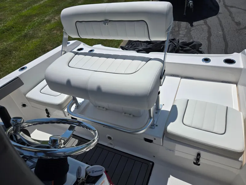 Slide: The Image of 2018 Yamaha Boats 210 FSH Sport interior with white seating and steering wheel. - 20