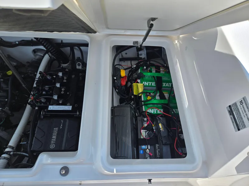 Slide: The Image of Engine compartment of 2018 Yamaha Boats 210 FSH Sport, showing batteries and wiring. - 22
