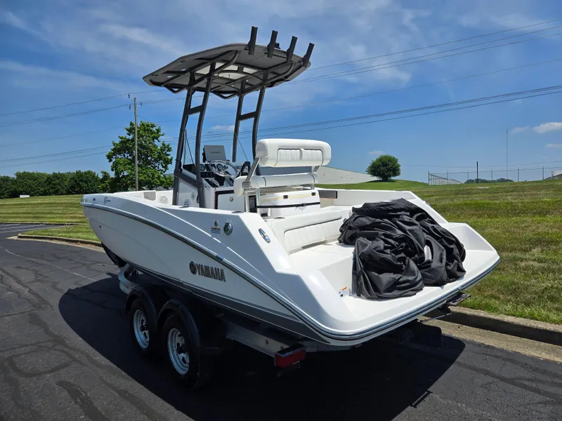 Slide: The Image of 2018 Yamaha Boats 210 FSH Sport on trailer, parked outdoors under clear blue sky. - 3