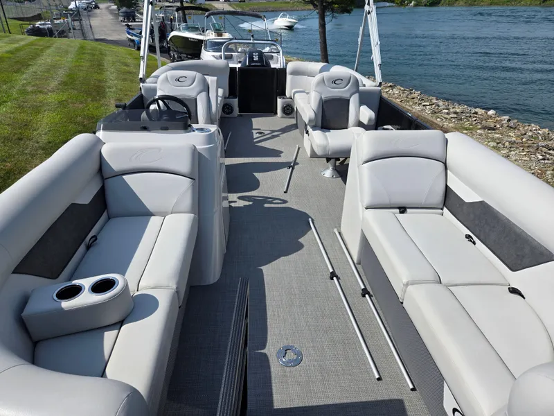 Slide: The Image of 2021 Crest Classic LX 220 SLC pontoon boat interior with plush seating and steering console. - 12