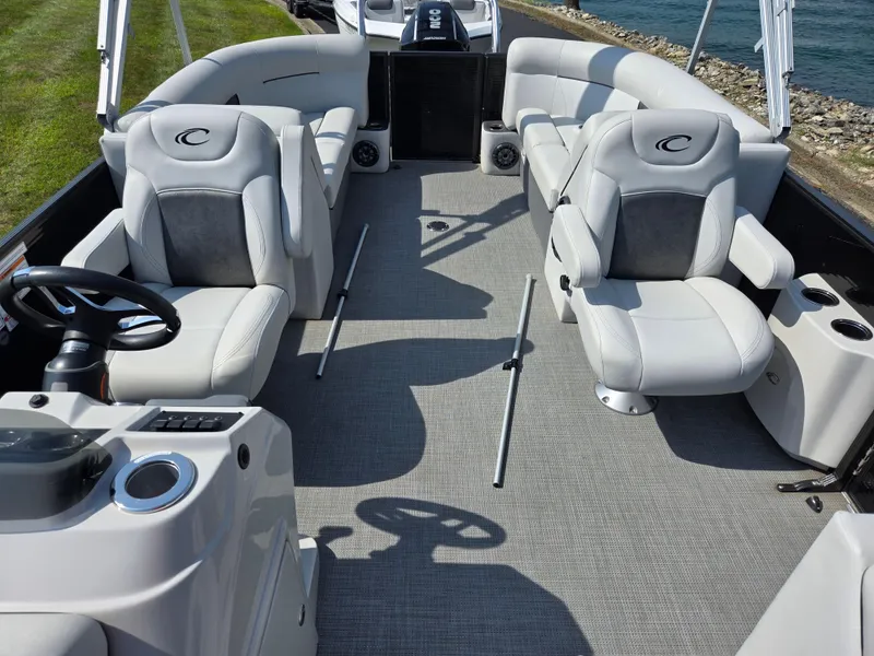 Slide: The Image of 2021 Crest Classic LX 220 SLC pontoon boat interior with plush seating and steering console. - 13