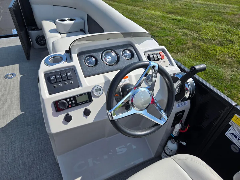 Slide: The Image of 2021 Crest Classic LX 220 SLC boat dashboard with steering wheel and controls. - 21