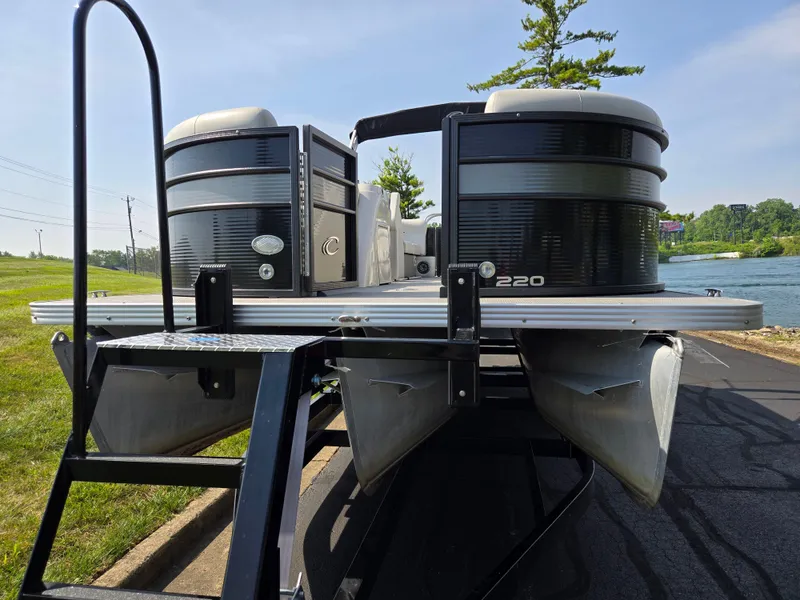 Slide: The Image of 2021 Crest Classic LX 220 SLC pontoon boat on trailer by a lake. - 6