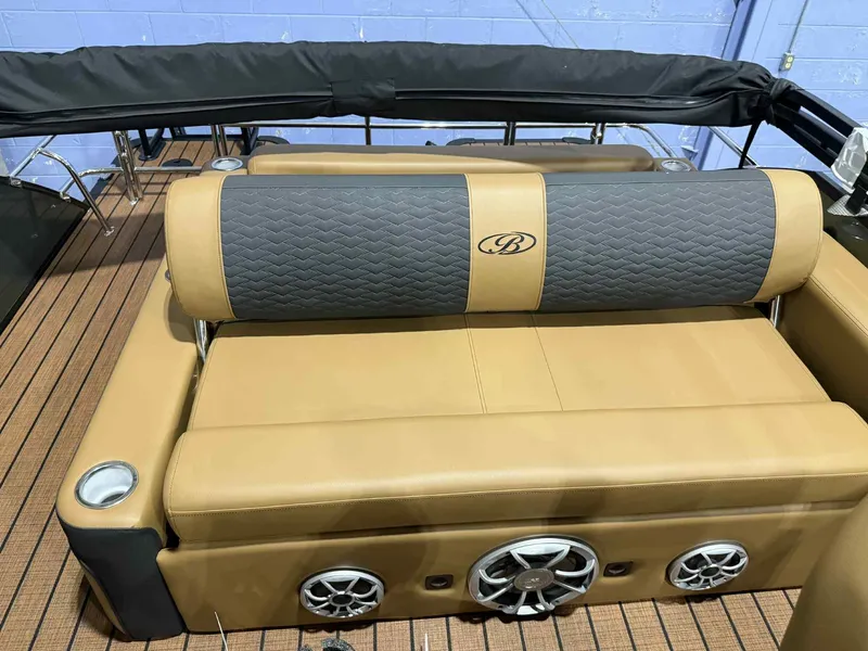 Slide: The Image of 2026 Bentley Pontoons Elite 223 Swingback interior with tan seating and speaker system. - 13