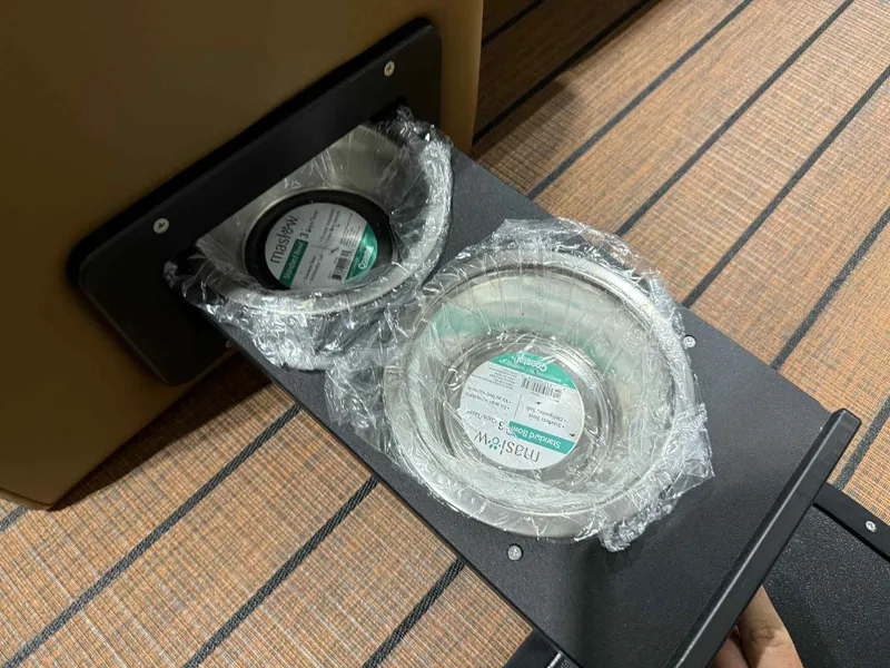 Slide: The Image of Built-in cup holders on 2026 Bentley Pontoons Elite 223 Swingback, featuring wrapped bowls on a wooden surface. - 8