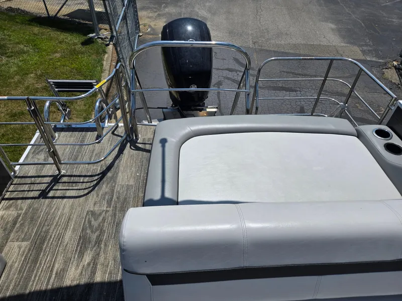 Slide: The Image of 2021 Godfrey SWEETWATER 2286 SFL boat with seating and outboard motor, docked on pavement. - 14