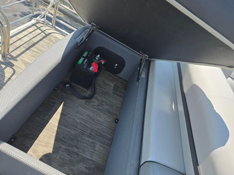 Slide: The Image of Open storage compartment in 2021 Godfrey SWEETWATER 2286 SFL boat, revealing battery and wiring. - 17