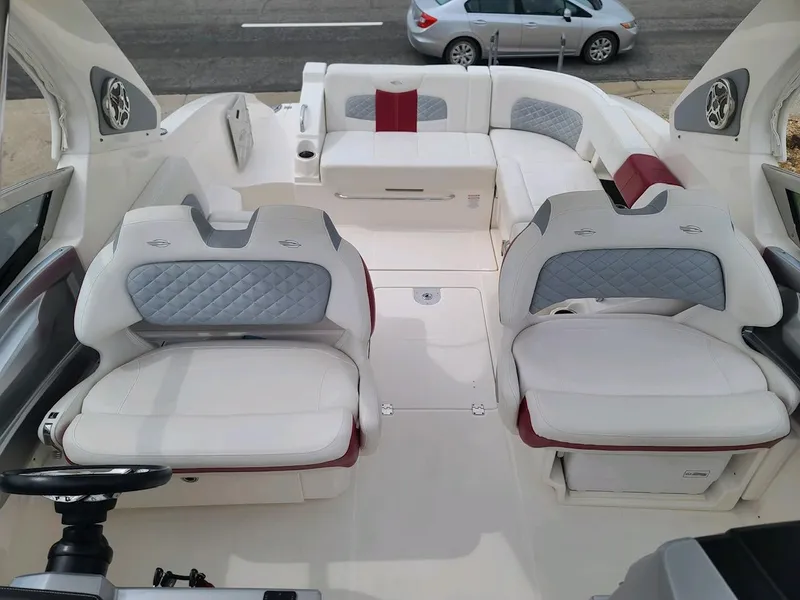Slide: The Image of 2013 Chaparral 327 SSX boat interior with white and gray seating, steering wheel visible. - 14