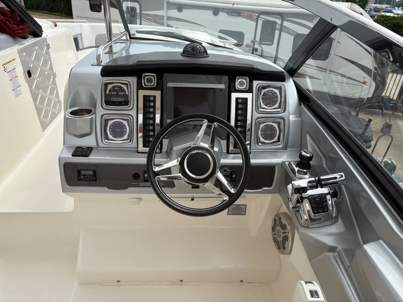 Slide: The Image of 2013 Chaparral 327 SSX boat dashboard with steering wheel and control panel. - 17