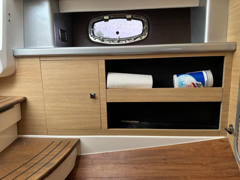 Slide: The Image of Interior of 2013 Chaparral 327 SSX boat with wooden cabinetry and storage shelves. - 24