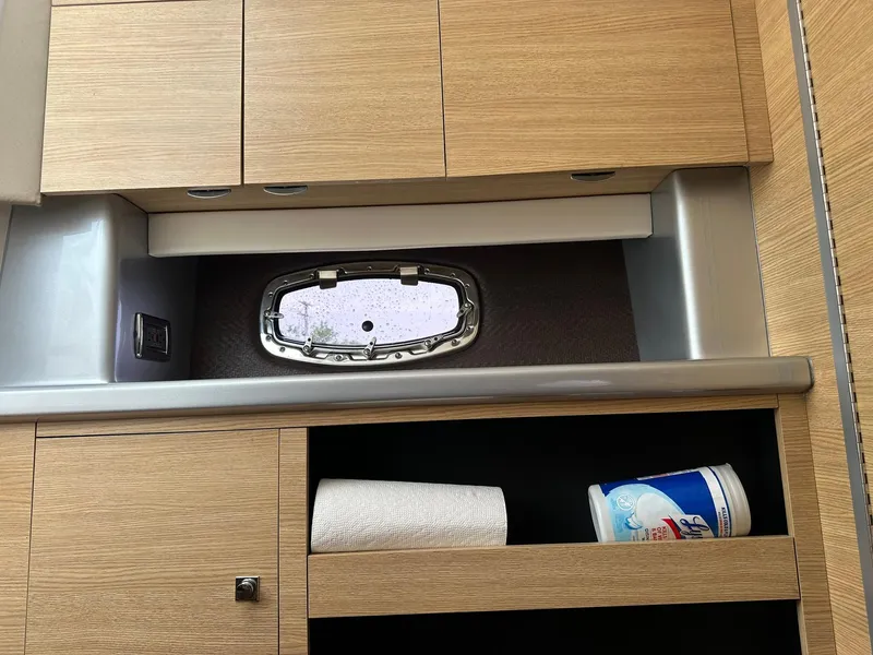 Slide: The Image of Interior of 2013 Chaparral 327 SSX boat with wooden cabinets and small window. - 25