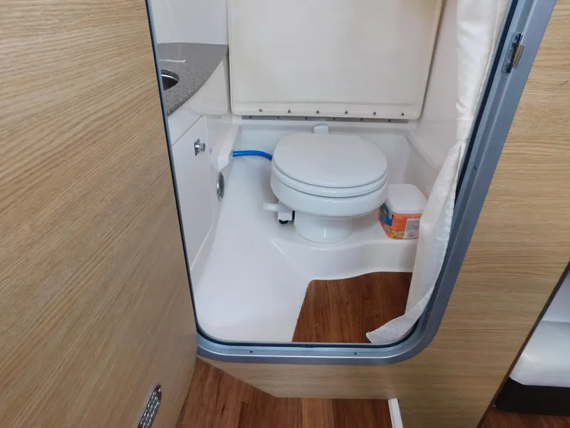 Slide: The Image of 2013 Chaparral 327 SSX boat bathroom with toilet and sink. - 31