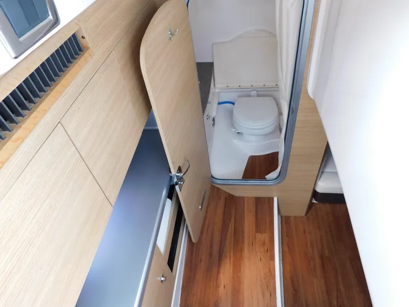 Slide: The Image of Interior of 2013 Chaparral 327 SSX boat showing bathroom and wooden flooring. - 32