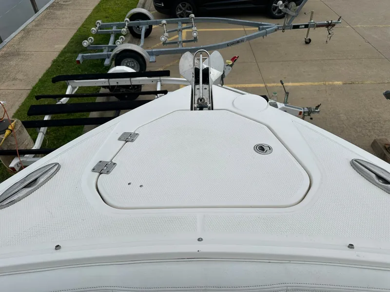 Slide: The Image of Bow view of a 2013 Chaparral 327 SSX boat with trailers in the background. - 4