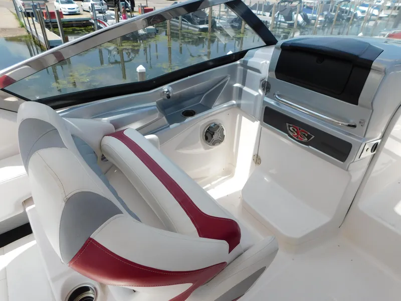Slide: The Image of 2013 Chaparral 327 SSX boat interior with red and white seating, sleek dashboard design. - 43