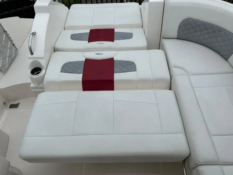 Slide: The Image of 2013 Chaparral 327 SSX boat interior with white and gray seating, red accents. - 47