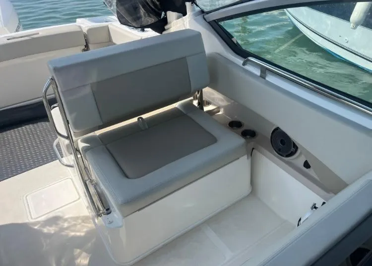 Slide: The Image of 2023 Boston Whaler 240 Vantage boat interior with cushioned seating and cup holders. - 14