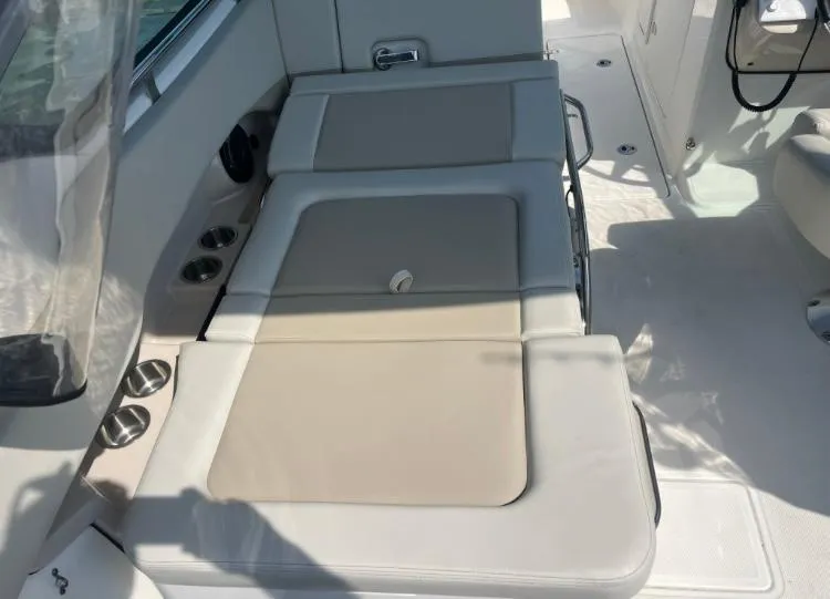 Slide: The Image of 2023 Boston Whaler 240 Vantage interior seating with beige cushions and cup holders. - 16
