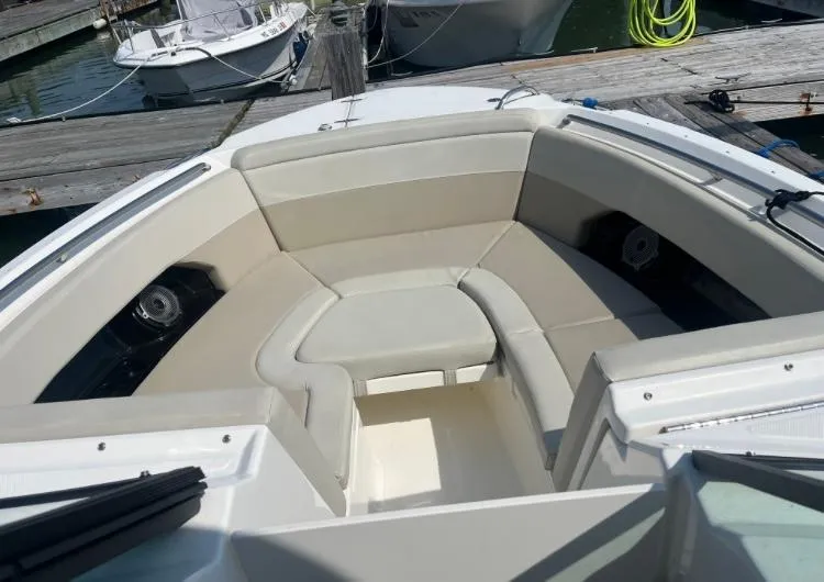 Slide: The Image of 2023 Boston Whaler 240 Vantage boat interior with cushioned seating at dock. - 18