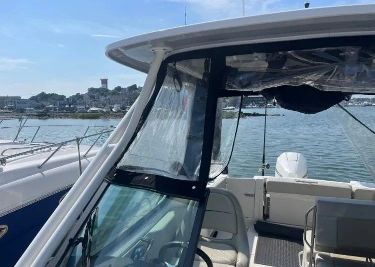 Slide: The Image of 2023 Boston Whaler 240 Vantage boat docked by scenic waterfront. - 6