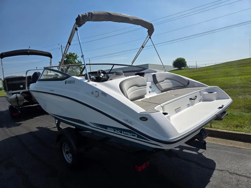 Slide: The Image of 2021 Yamaha SX190 boat on trailer, white exterior, sunny day, grassy background. - 3