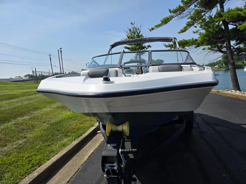 Slide: The Image of 2021 Yamaha Boats SX190 on trailer by a lakeside road. - 6