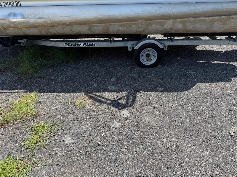 Slide: The Image of 2009 Premier 200 SunSpree boat on trailer, parked on gravel with grass patches. - 4