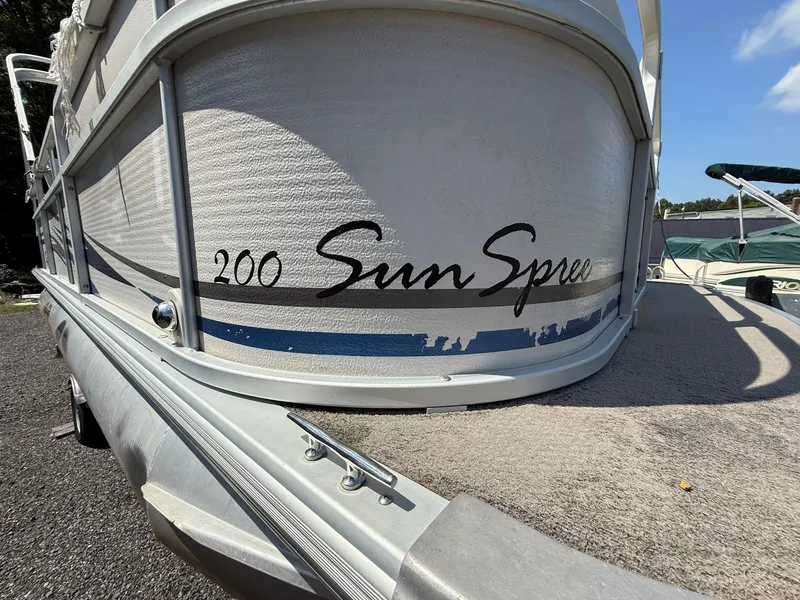 Slide: The Image of 2009 Premier 200 SunSpree pontoon boat, side view with logo, parked outdoors. - 7
