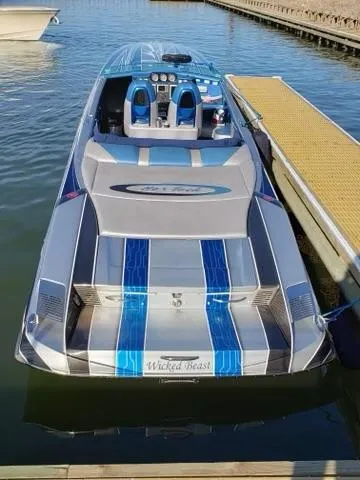 Slide: The Image of 2013 Nor-Tech 477 SPX Vee Bottom boat docked, featuring sleek design and blue accents. - 13