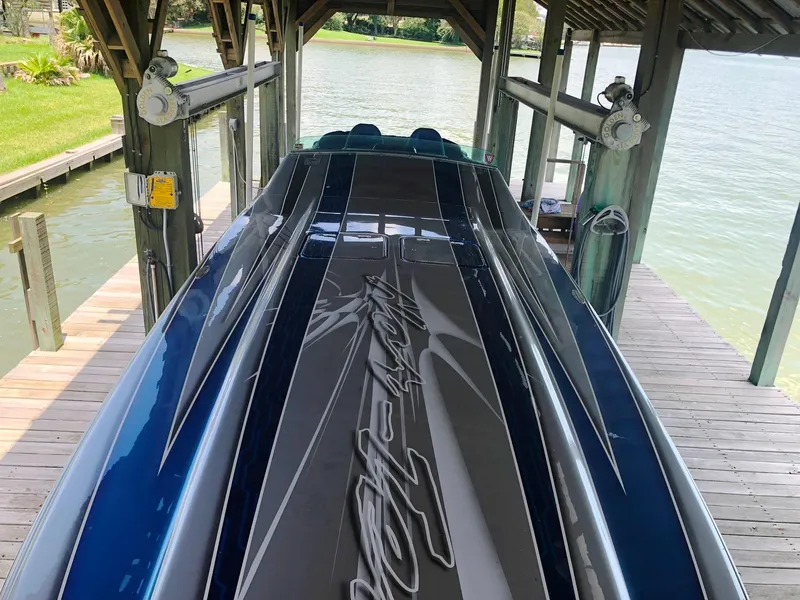 Slide: The Image of 2013 Nor-Tech 477 SPX Vee Bottom boat docked under a wooden shelter. - 19