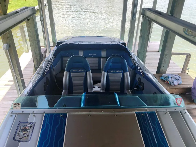 Slide: The Image of 2013 Nor-Tech 477 SPX Vee Bottom boat docked, featuring blue and gray seating. - 21