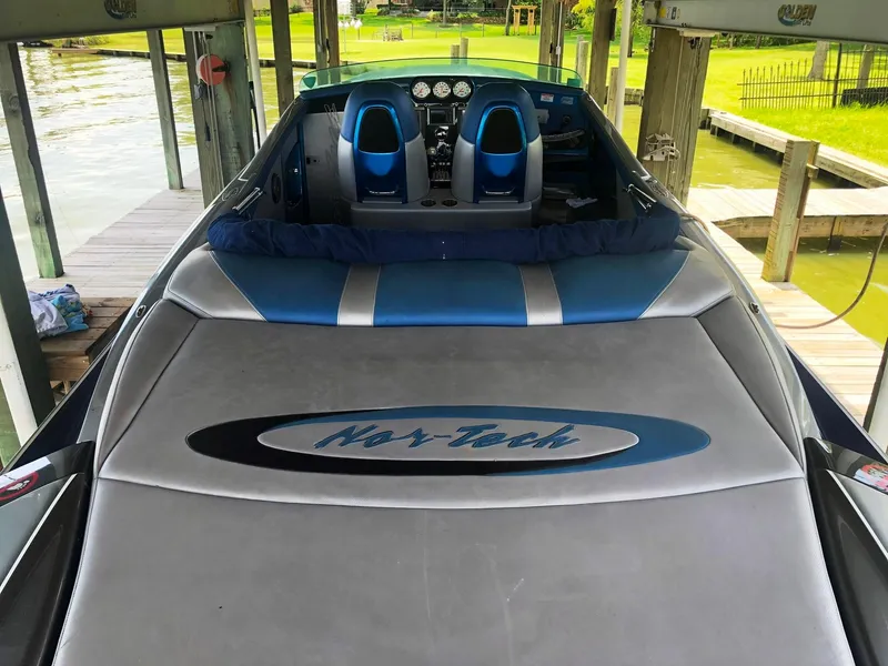 Slide: The Image of 2013 Nor-Tech 477 SPX Vee Bottom boat docked, featuring sleek blue and gray design. - 24