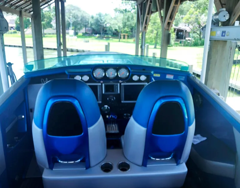 Slide: The Image of Interior view of 2013 Nor-Tech 477 SPX Vee Bottom boat with blue seating and dashboard controls. - 25
