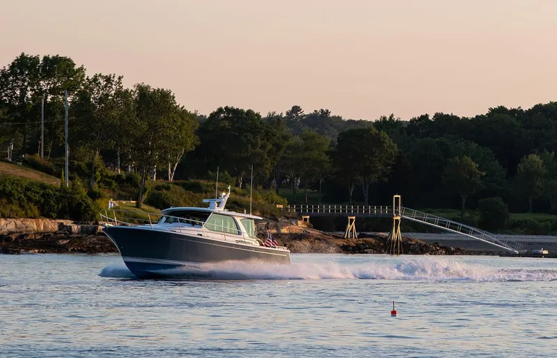 The Image of 2026 Sabre 43 Salon Express cruising on a scenic waterway at sunset. - 1
