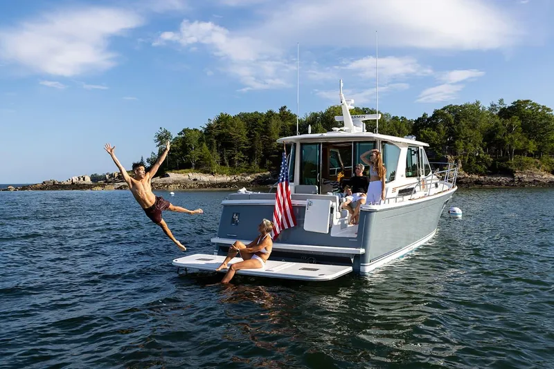 Slide: The Image of 2026 Sabre 43 Salon Express yacht with people enjoying water activities. - 3