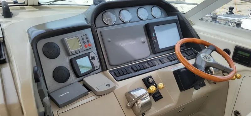 Slide: The Image of 2005 Sea Ray 390 Motor Yacht helm with navigation instruments and wooden steering wheel. - 2