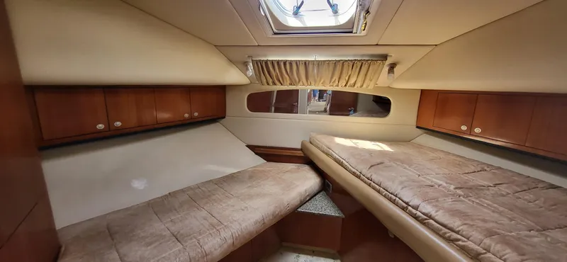 Slide: The Image of 2005 Sea Ray 390 Motor Yacht cabin with twin beds and wooden cabinetry. - 22