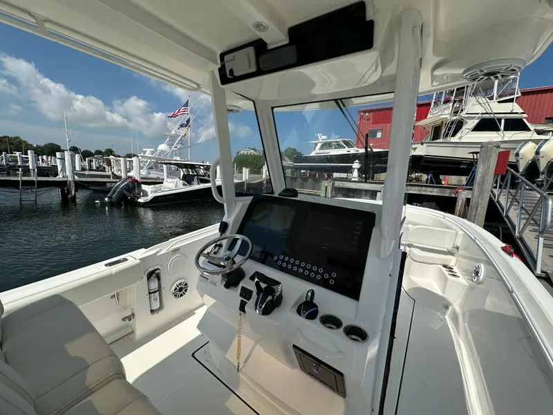 Slide: The Image of Interior view of 2023 Edgewater 285CC boat at a marina, featuring a modern control panel. - 14