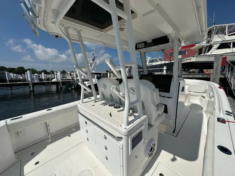 Slide: The Image of 2023 Edgewater 285CC boat interior with helm station, docked at marina. - 16